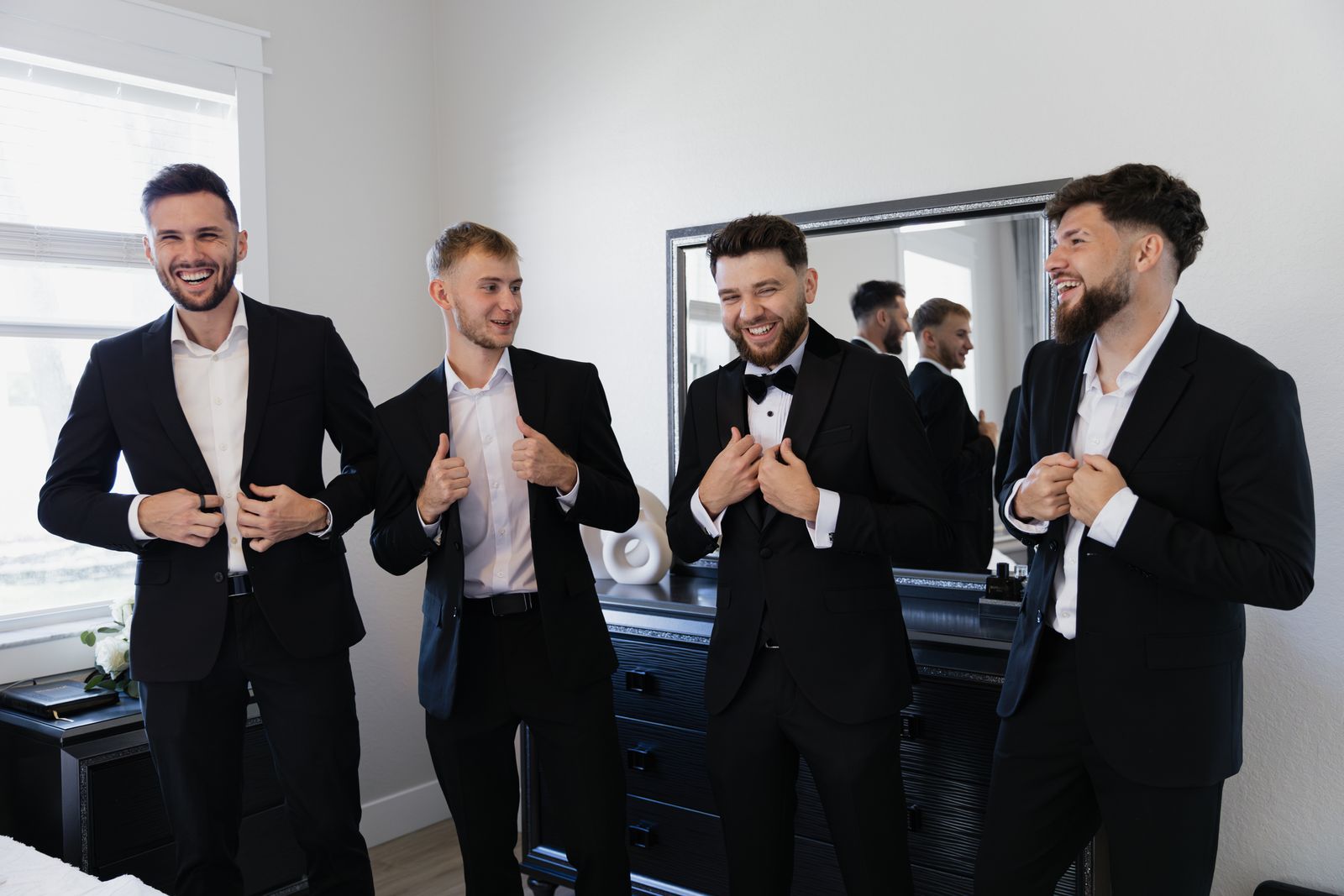 Groomsmen laughing together in black suits