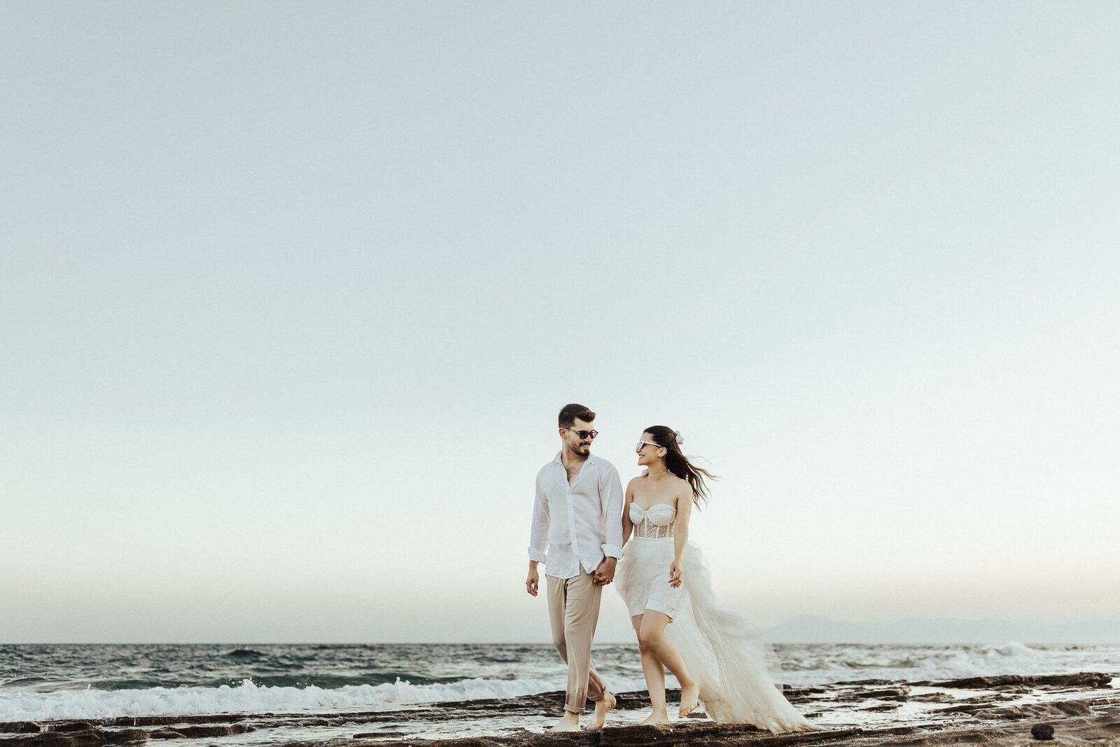 Sofia and Cameron walking together beside the sea