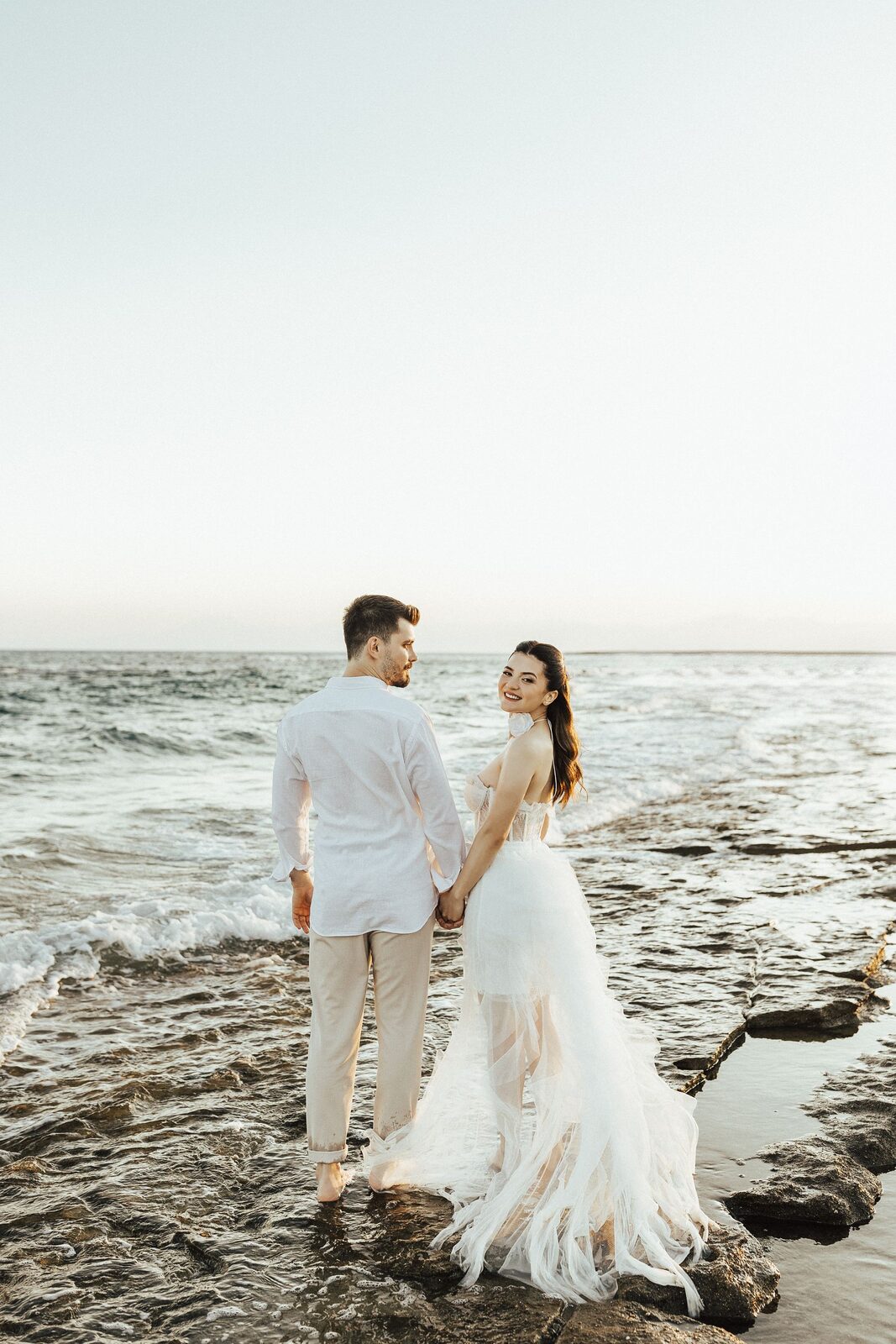 Sofia and Cameron walking hand in hand on the beach