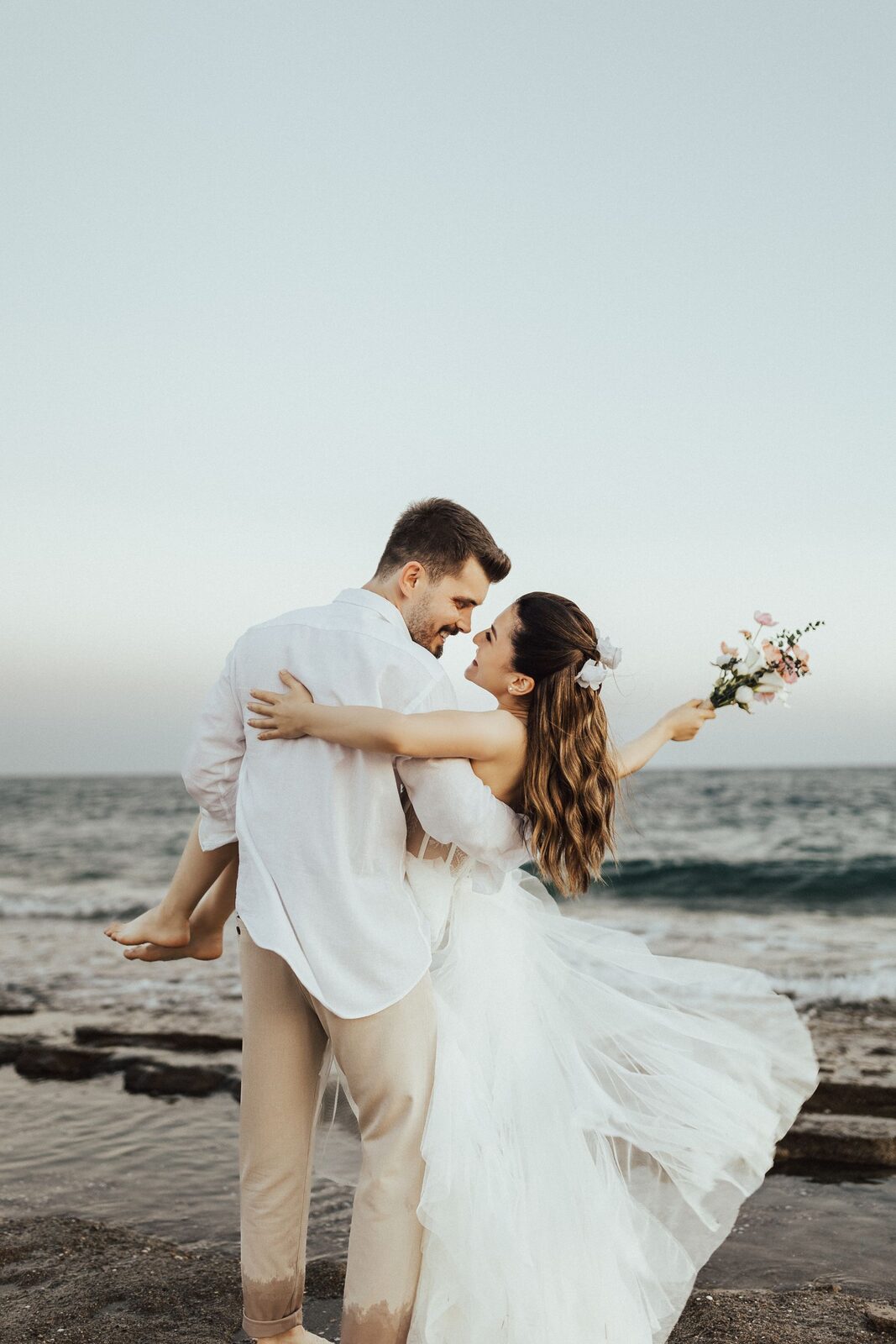 Sofia and Cameron embracing beside the sea
